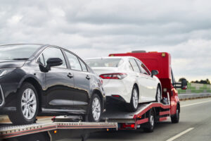 Tow truck with a broken car on a road. Tow truck transporting car on the highway. Car service transportation concept. Roadside Rescue.