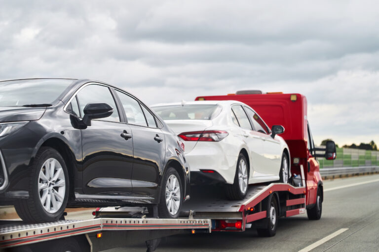 Tow truck with a broken car on a road. Tow truck transporting car on the highway. Car service transportation concept. Roadside Rescue.