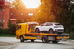 Tow truck with a broken car on a road. Tow truck transporting car on the highway. Car service transportation concept. Roadside Rescue.